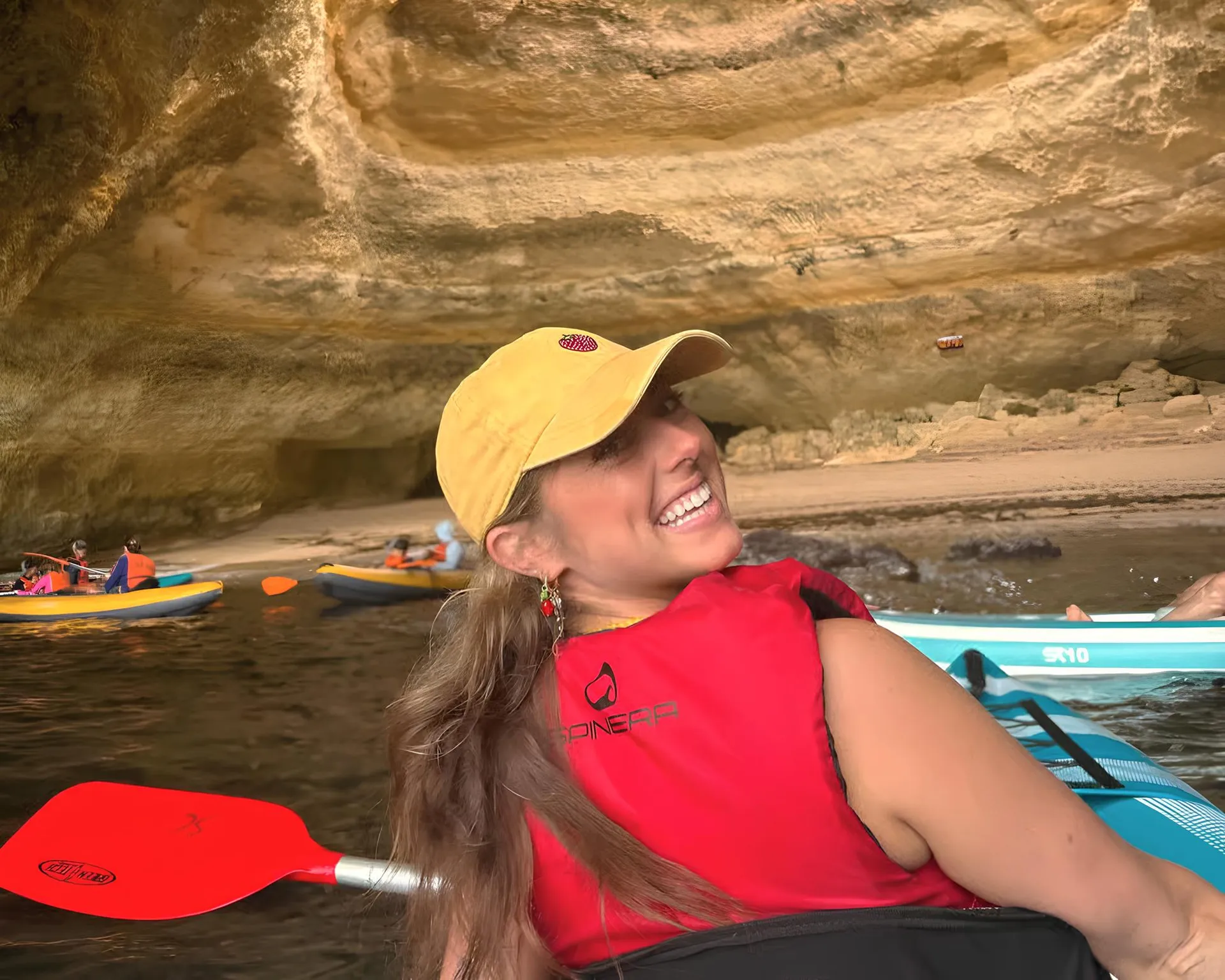 Happy guest smiling inside Benagil Cave from their kayak