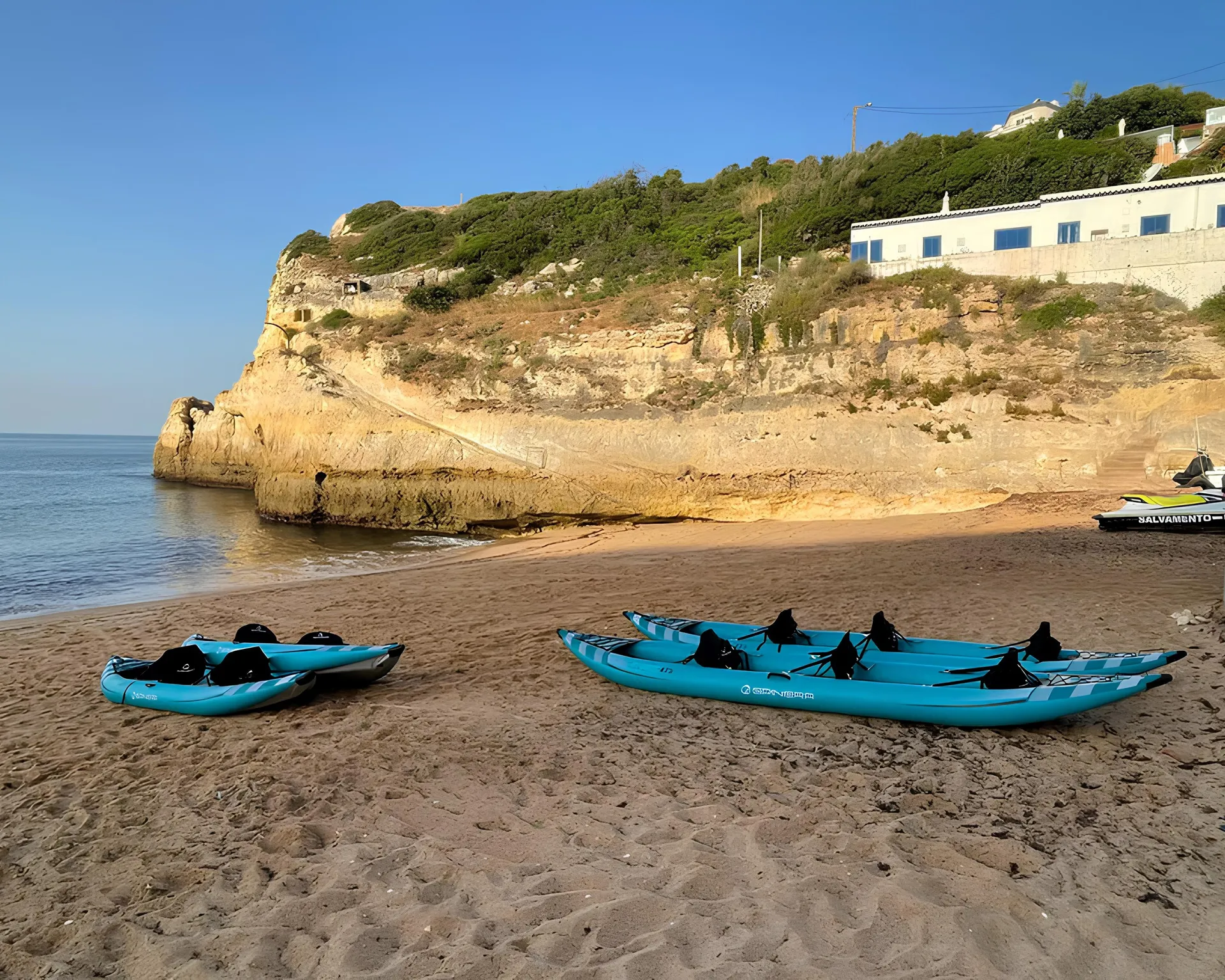 Colourful kayaks lined up on Benagil Beach ready for a tour