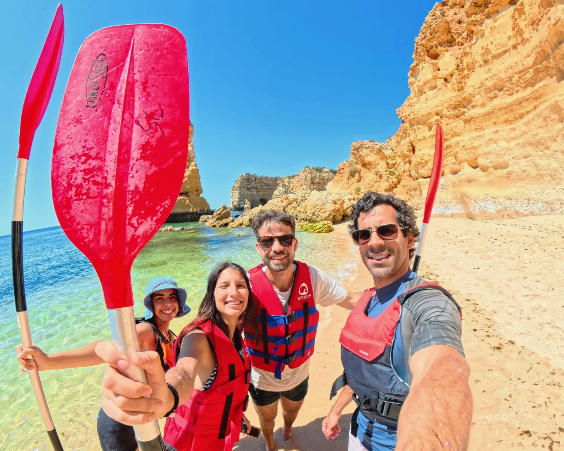 Tour group selfie on Benagil Beach with paddles up